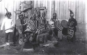 A group of Tlingit men outside a clan house.